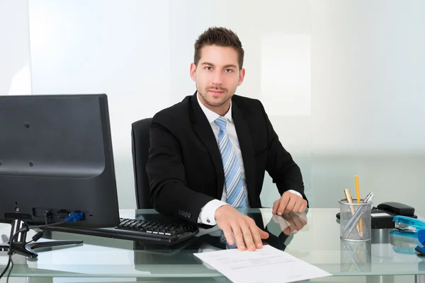 Confident Businessman With Document At Desk — Stock Photo, Image