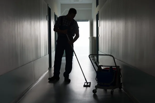 Hombre con escoba limpieza oficina corredor — Foto de Stock