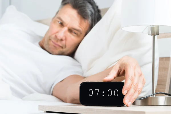 Mature Man Turning Off Clock — Stock Photo, Image