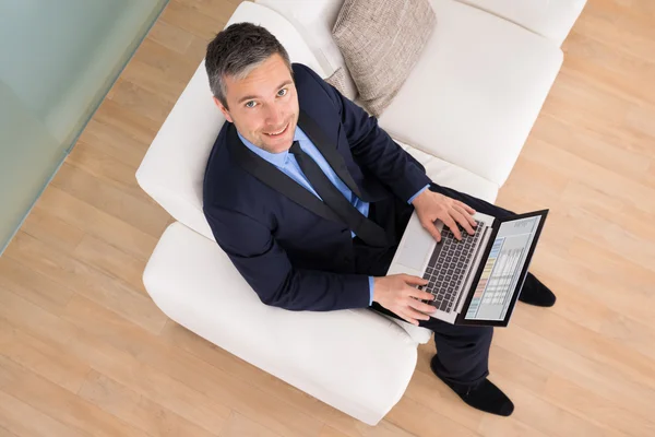 Businessman On Couch Using Laptop — Stock Photo, Image