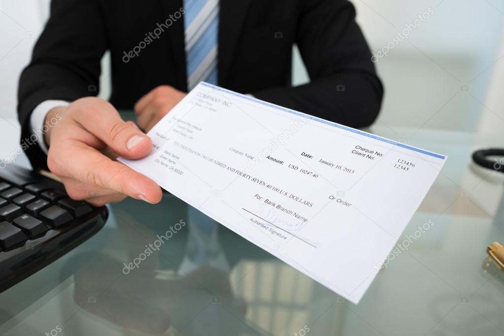 Midsection Of Businessman Giving Cheque