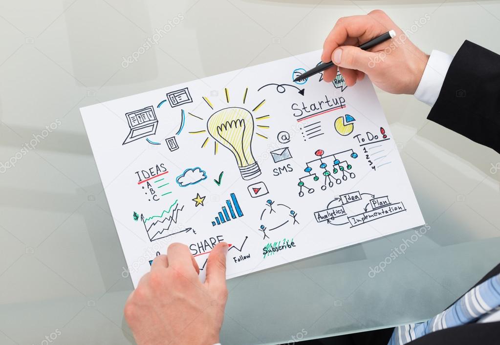 Businessman Drawing Management Chart At Desk