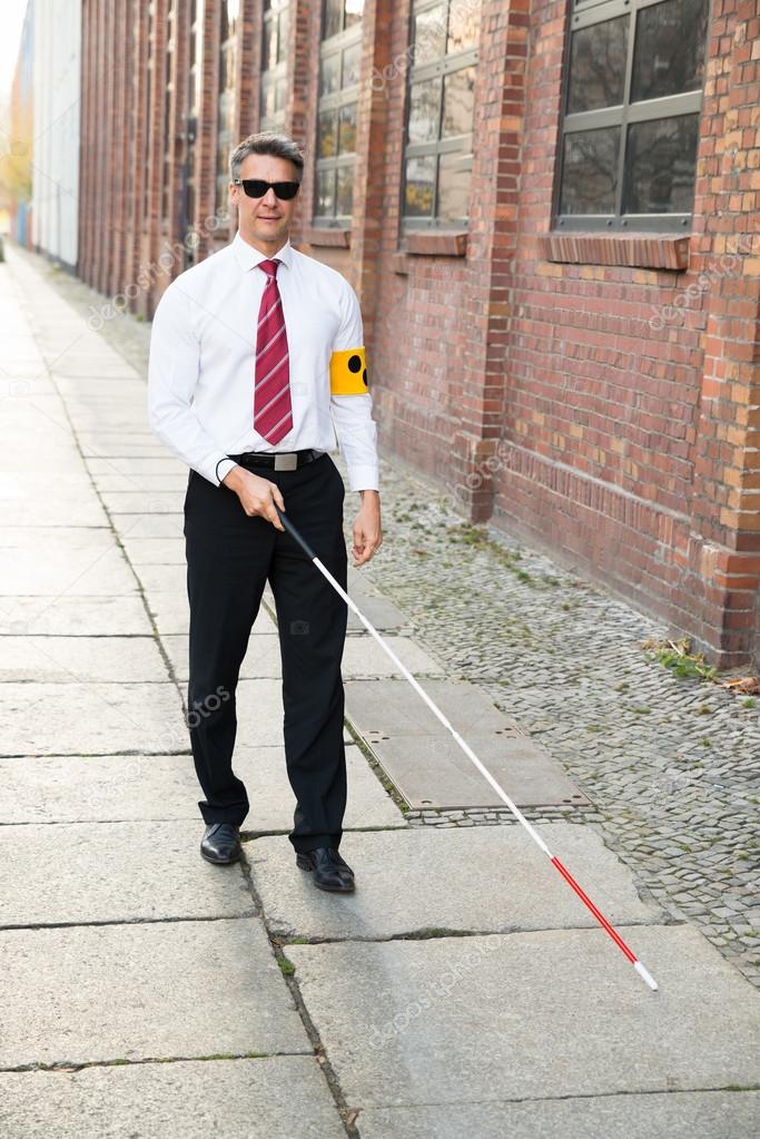 Blind Man Walking On Sidewalk