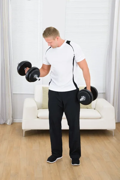 Homem muscular levantando pesos — Fotografia de Stock