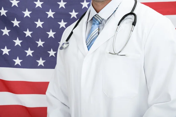 Médico frente a bandera americana — Foto de Stock