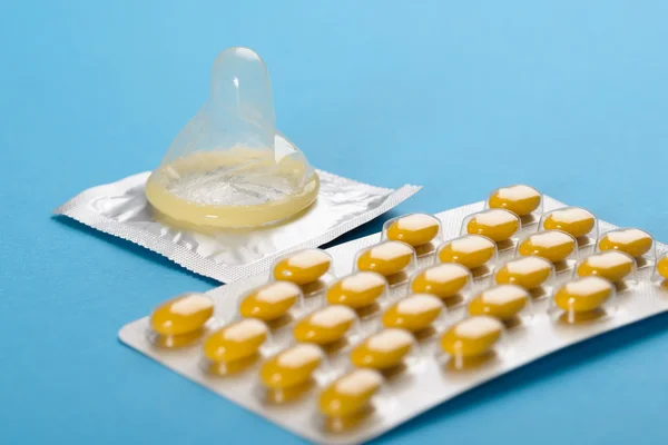 Контроль рождаемости с таблетками и презервативами — стоковое фото