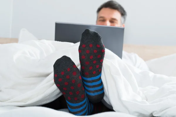 Homme avec chaussettes à l'aide d'un ordinateur portable — Photo