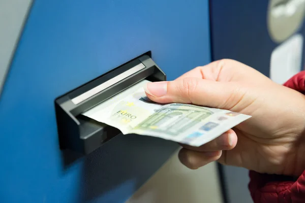 Frau steckt Bargeld in Automaten — Stockfoto
