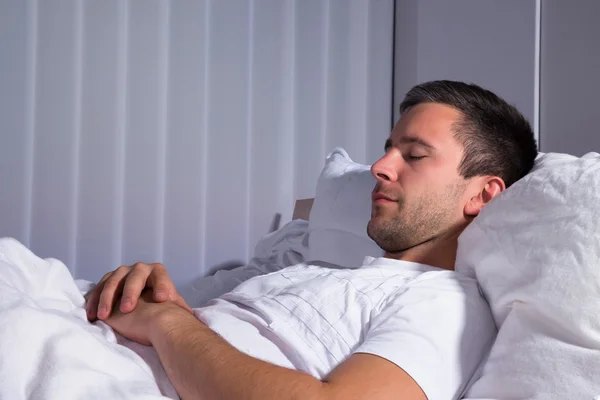 Мужчина, спящий на кровати — стоковое фото