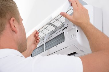 Man Adjusting Air Conditioning System clipart