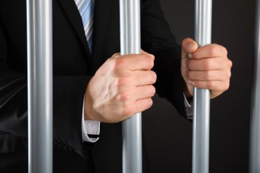 Businessman Holding Bars In Jail clipart