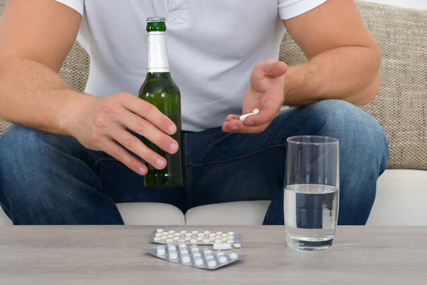 Hombre con pastillas y botella — Foto de Stock