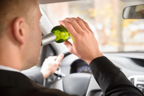 Человек пьет пиво в машине — стоковое фото