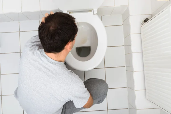 El hombre vomitando en el inodoro — Foto de Stock
