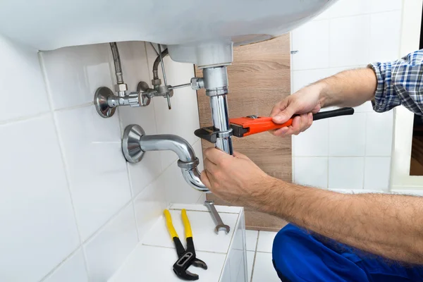 Mannelijke loodgieter vaststelling wastafel — Stockfoto