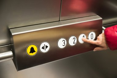 Kişi basarak birinci kat düğmesine