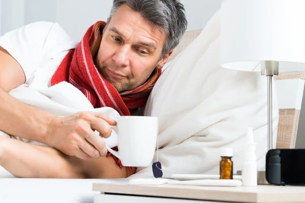 Homem tomando café na cama — Fotografia de Stock