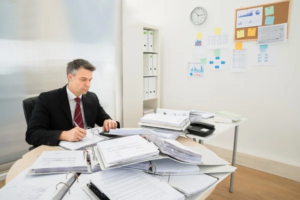 Empresario con montón de carpetas — Foto de Stock