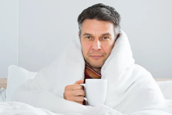 Hombre enfermo sosteniendo una taza de café — Foto de Stock