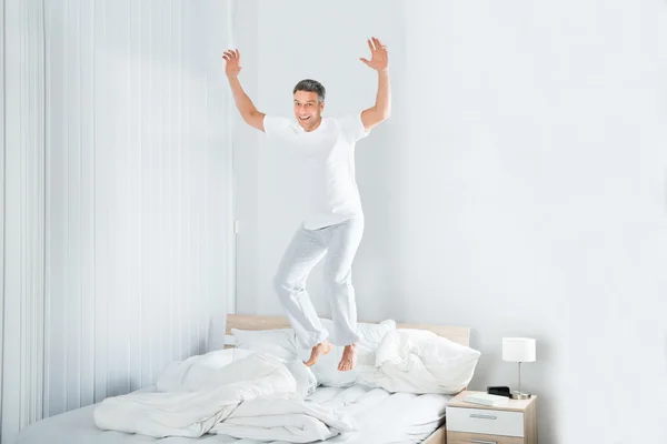 Hombre saltando en la cama — Foto de Stock