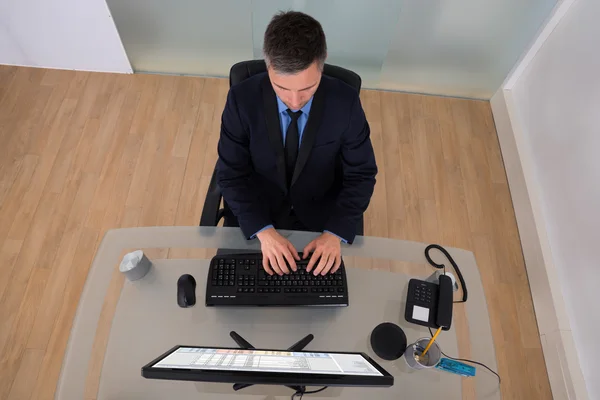 Forretningsmand ved hjælp af Computer In Office - Stock-foto