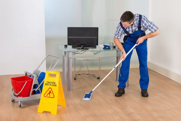 Oficina de hombre Mopping con señal de piso húmedo —  Fotos de Stock