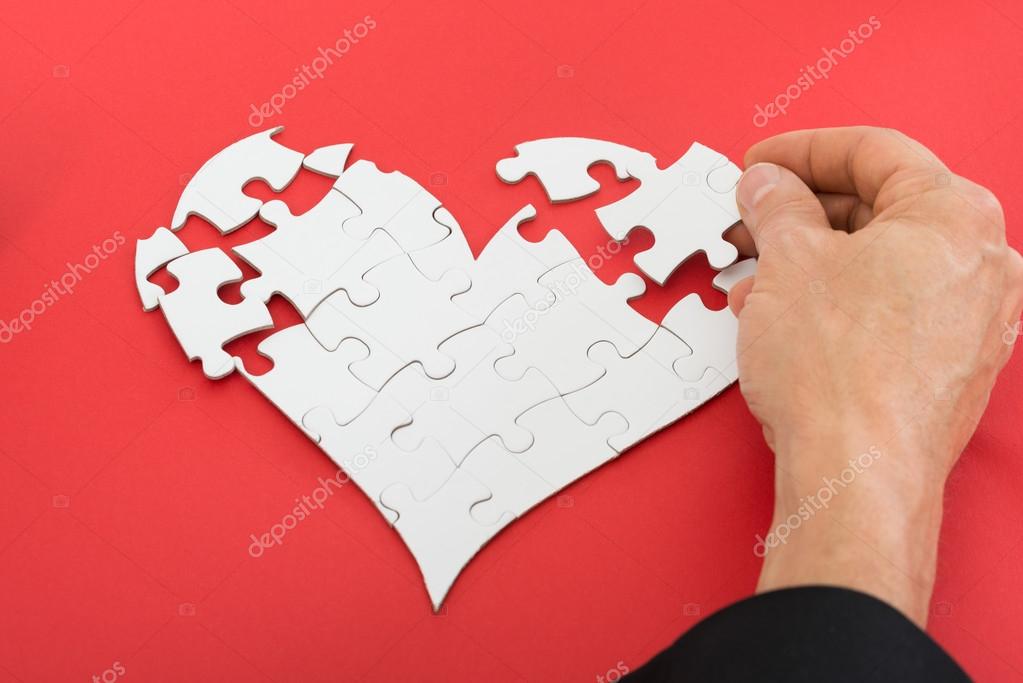 Person Solving Heart-shaped Puzzle