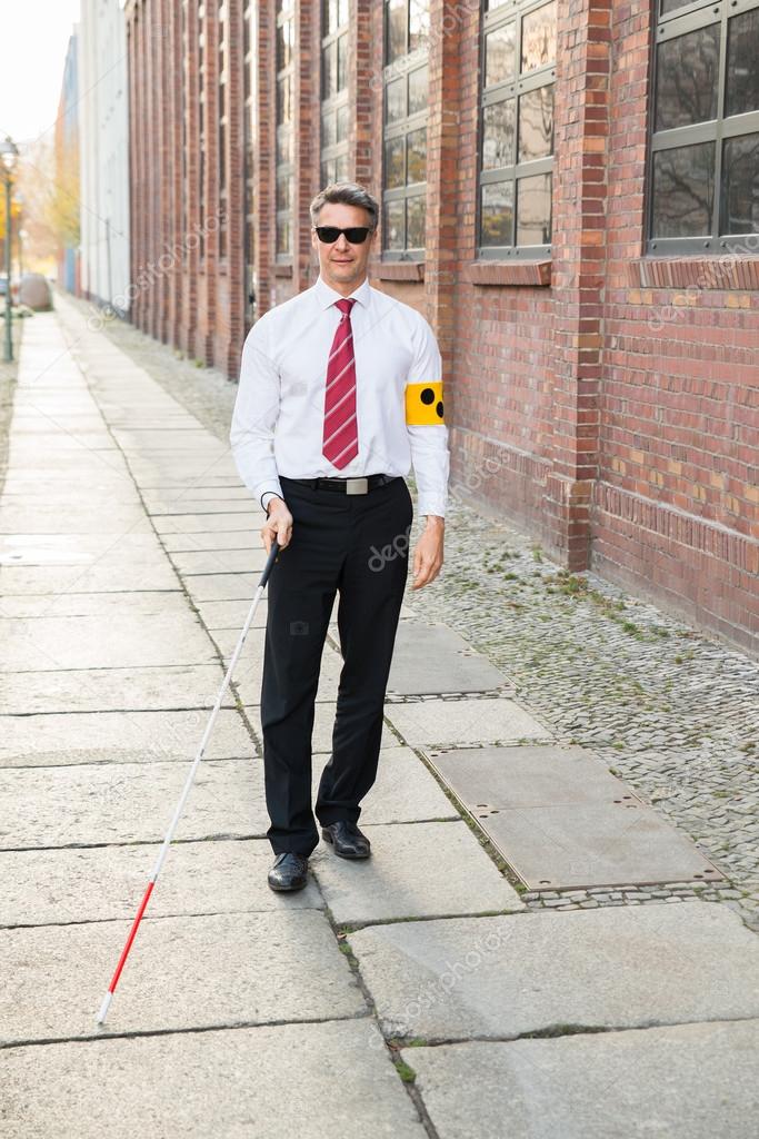 Blind Man Walking On Sidewalk