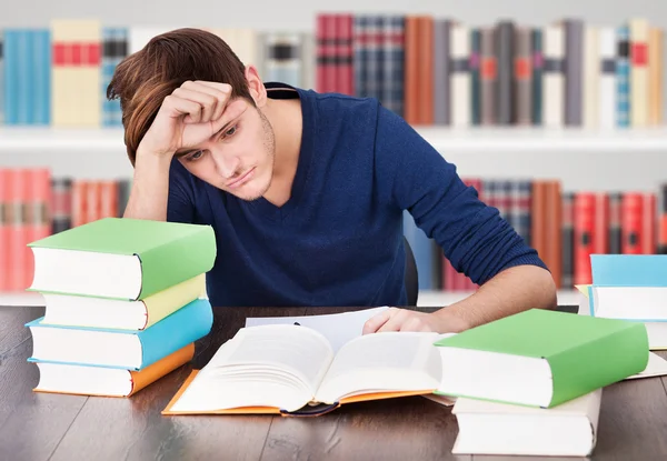 Joven hombre cansado en la biblioteca —  Fotos de Stock