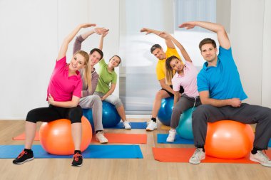 Pilates topu üzerinde oturan insanlar