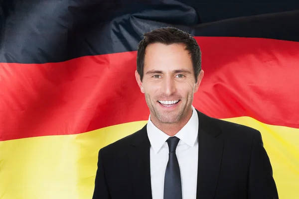 Бизнесмен перед германским флагом — стоковое фото