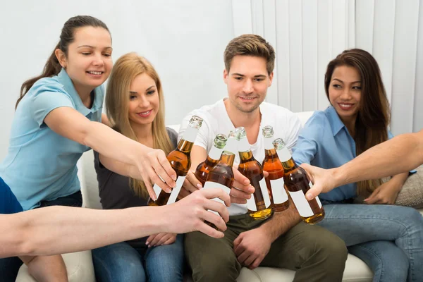 Freunde stoßen auf Bierflaschen an — Stockfoto