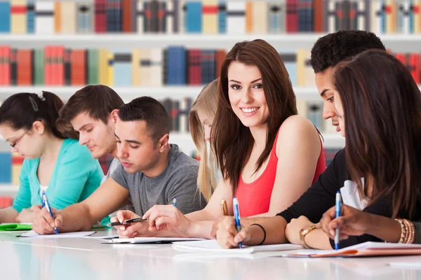 Studenten schreiben am Schreibtisch — Stockfoto