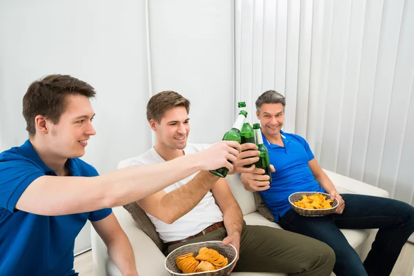 Freunde stoßen auf Bierflaschen an — Stockfoto