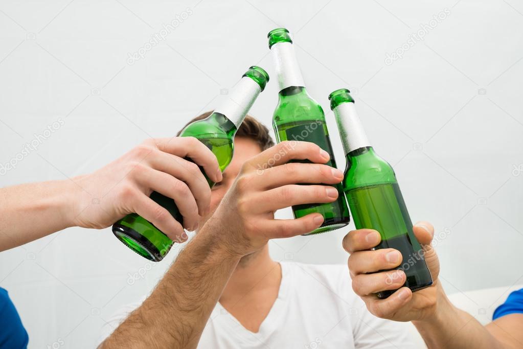 Men Toasting Beer Bottles