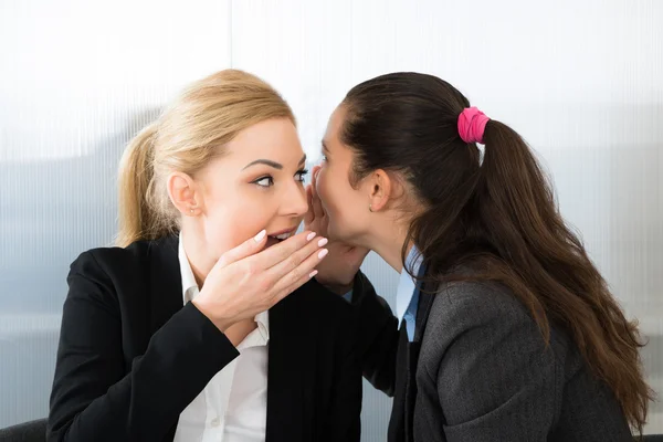 Businesswoman Whispering To Colleague — Stock Photo, Image