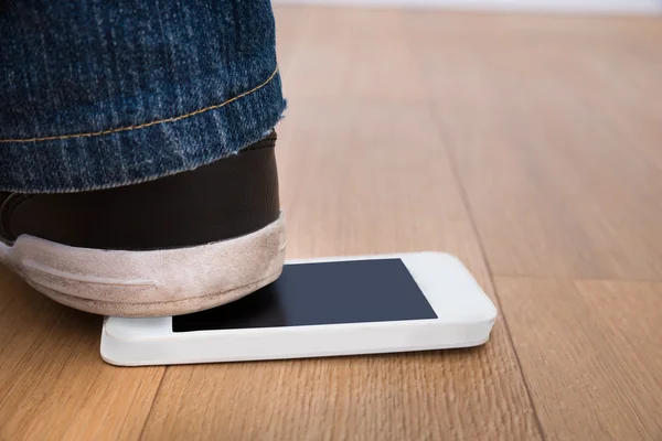 El pie de la persona sobre el teléfono celular —  Fotos de Stock
