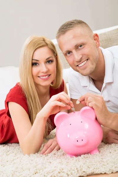 Par infoga mynt i Piggybank — Stockfoto