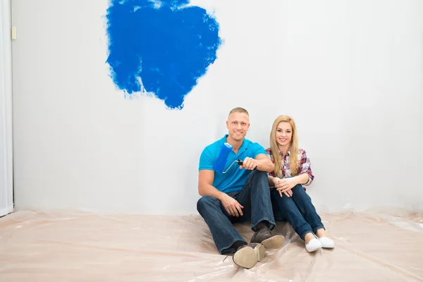 Paar en gedeeltelijk geschilderde muur — Stockfoto