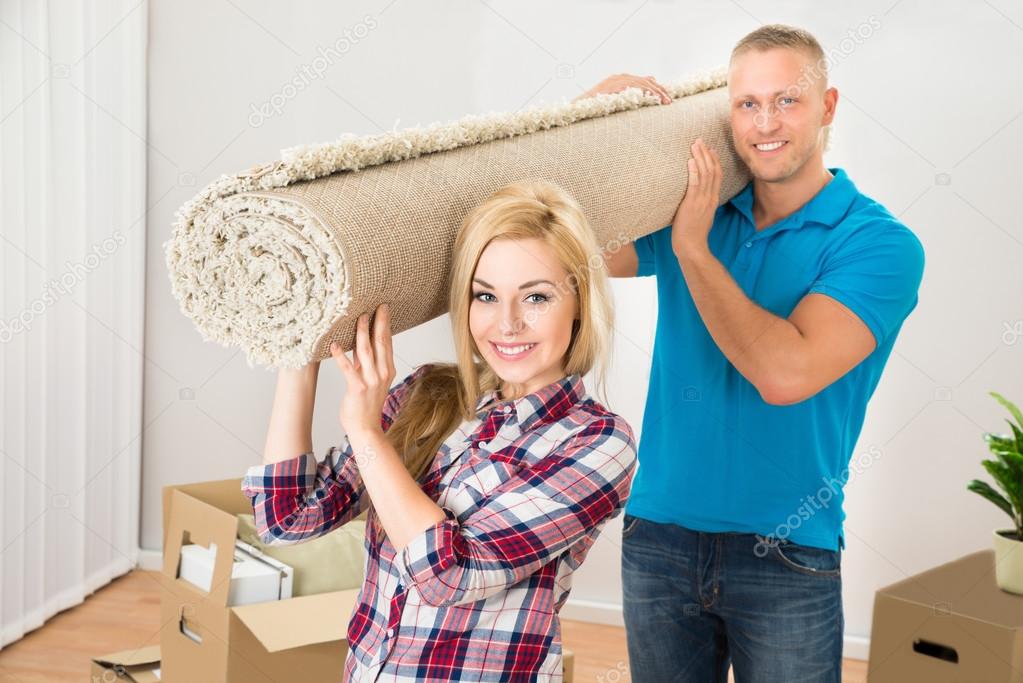 Couple Carrying Rolled Carpet
