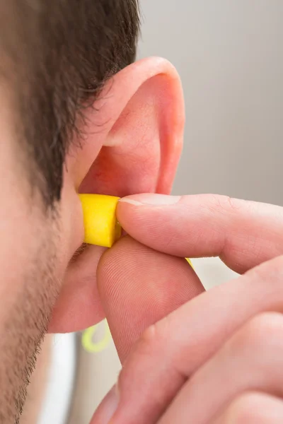 Fone de ouvido amarelo na orelha — Fotografia de Stock