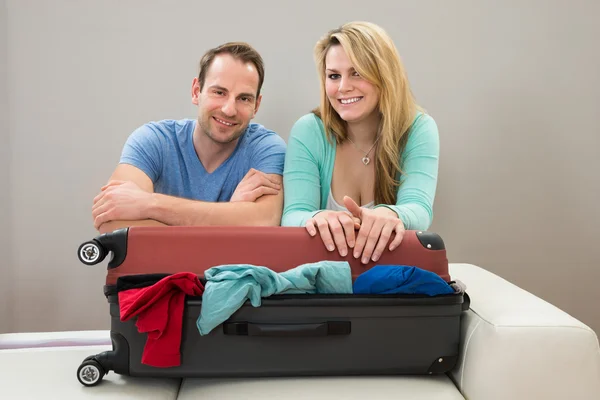 Paar stützt sich auf Koffer — Stockfoto