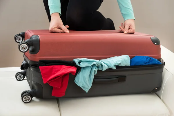 Vrouw probeert te sluiten koffer — Stockfoto