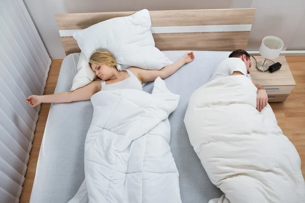 Pareja durmiendo en la cama — Foto de Stock