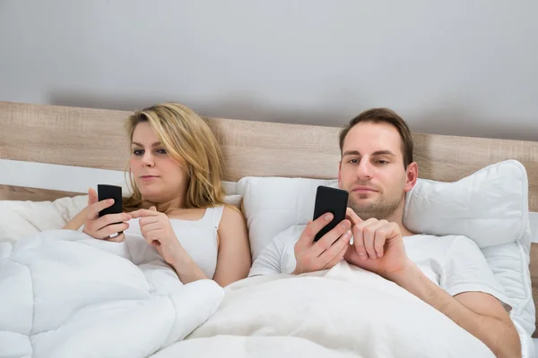 Couple avec téléphones mobiles — Photo