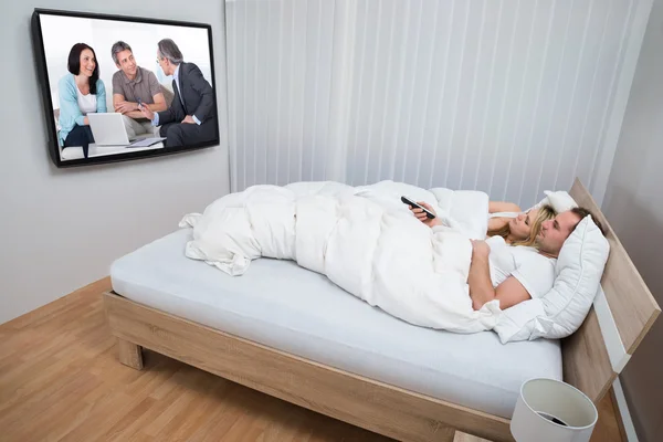 Para w łóżku oglądania telewizji — Zdjęcie stockowe