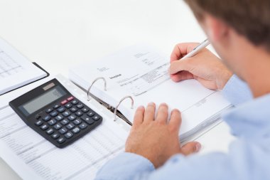 Businessman Calculating Tax In Office