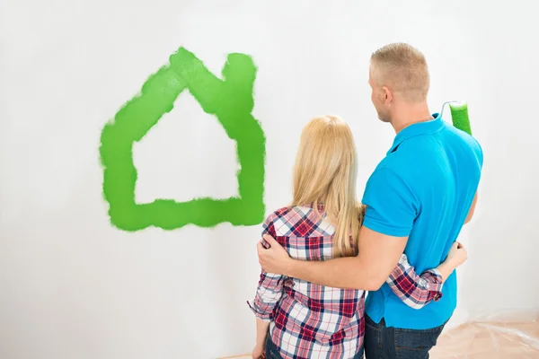 Casal na frente da casa pintada — Fotografia de Stock