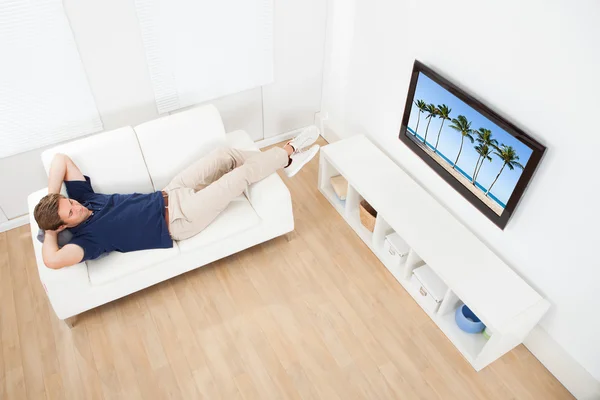 Człowiek ogląda plazy na Tv — Zdjęcie stockowe
