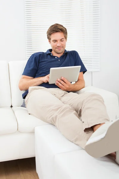 Homme détendu utilisant une tablette numérique — Photo